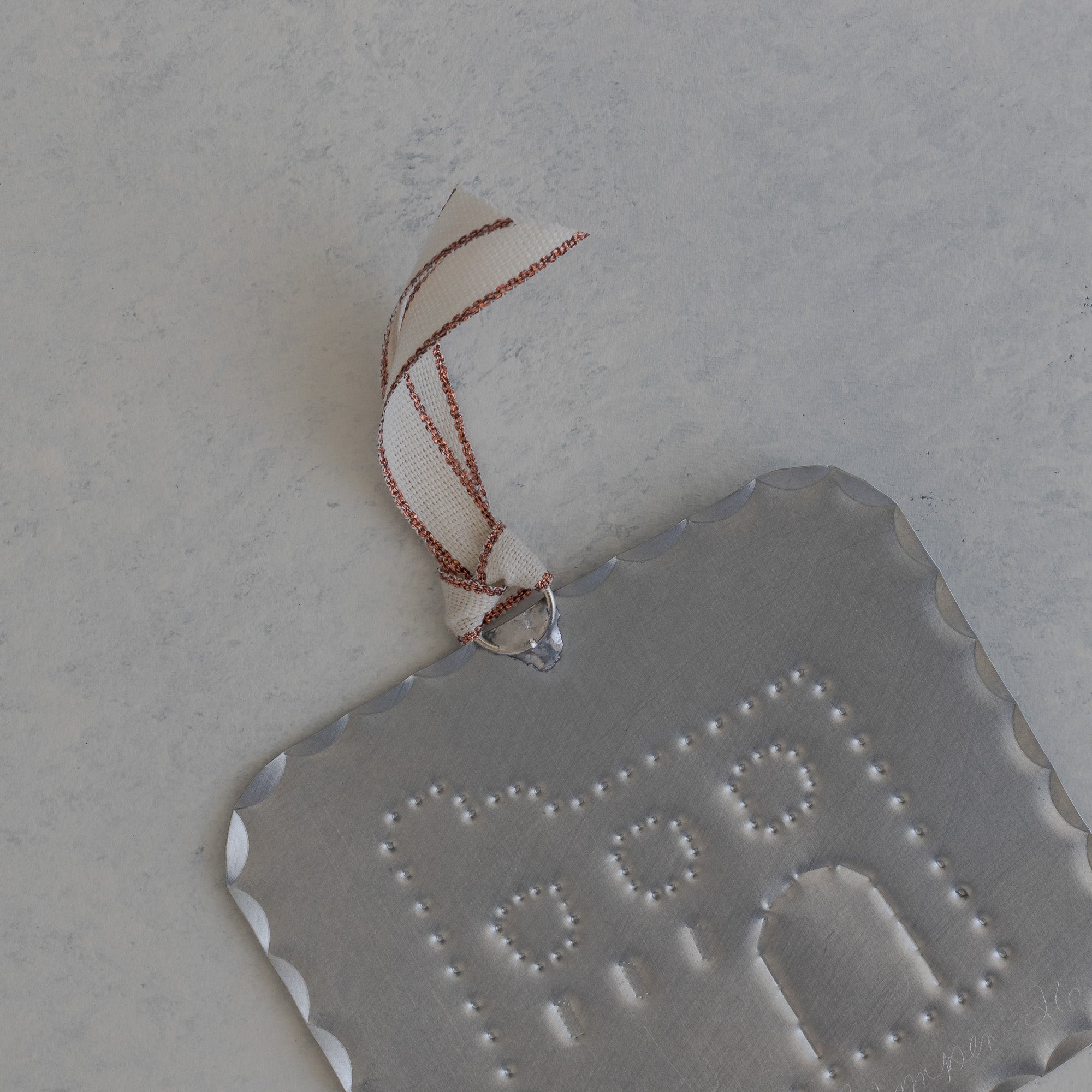 Back of the Adobe Milagro showing scalloped edge and rose gold ribbon