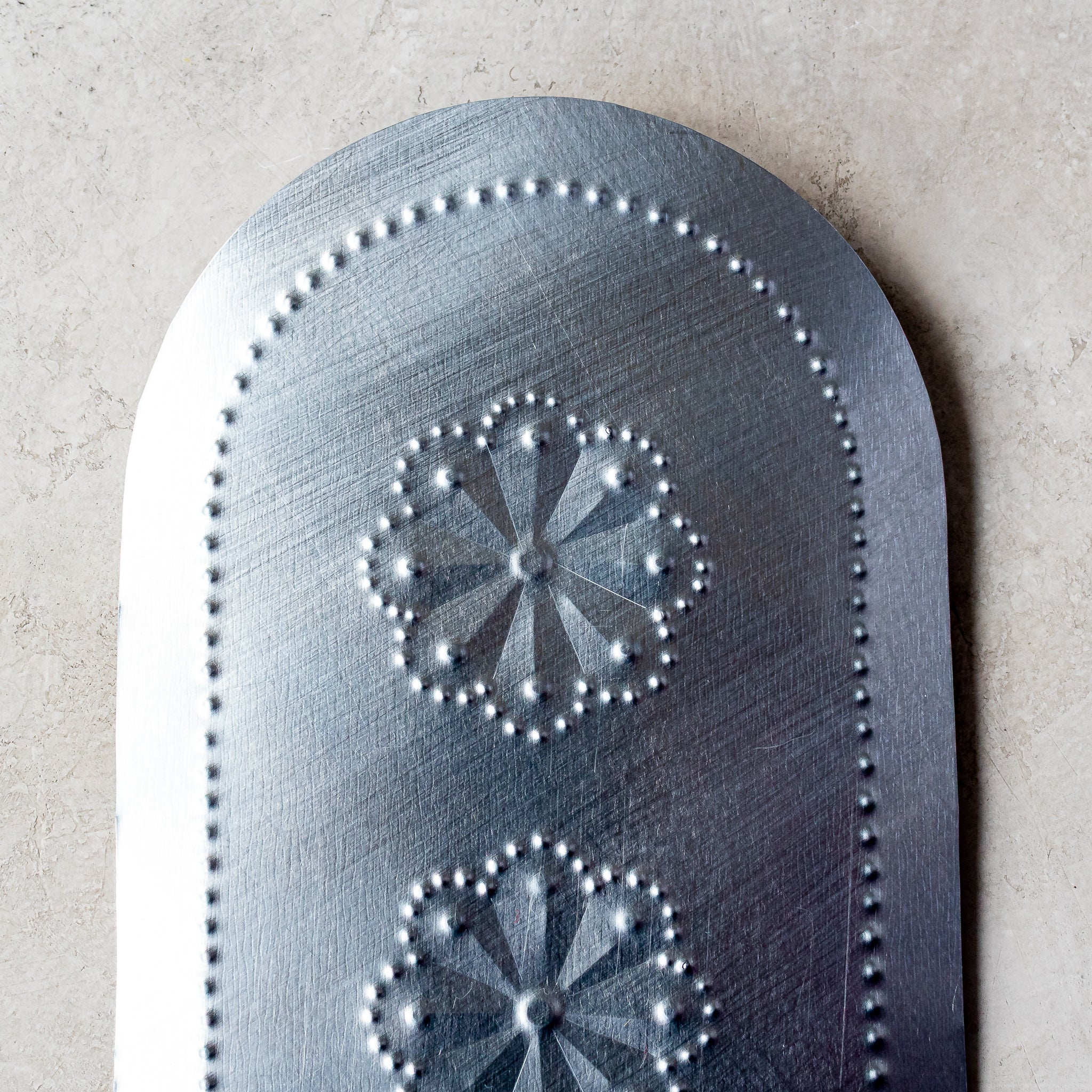 Close-up of the Roseta Trio Taper Holder showing detailed rosette pattern and textured tin surface.