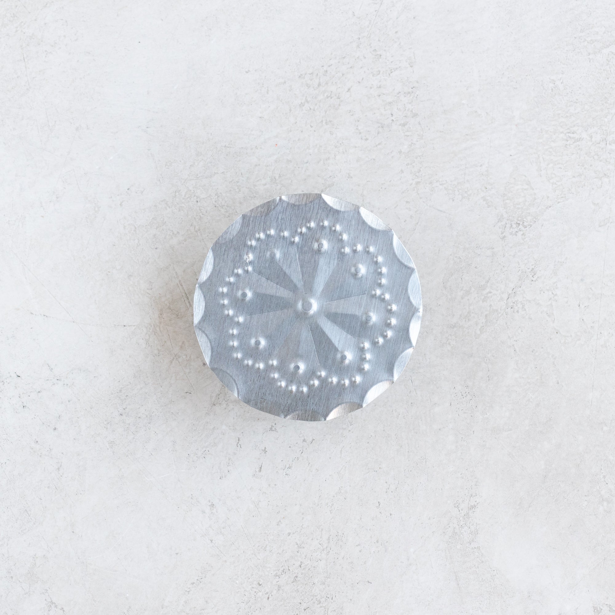 Roseta bandana slide photographed flat to highlight the hand-punched tin rosette design.