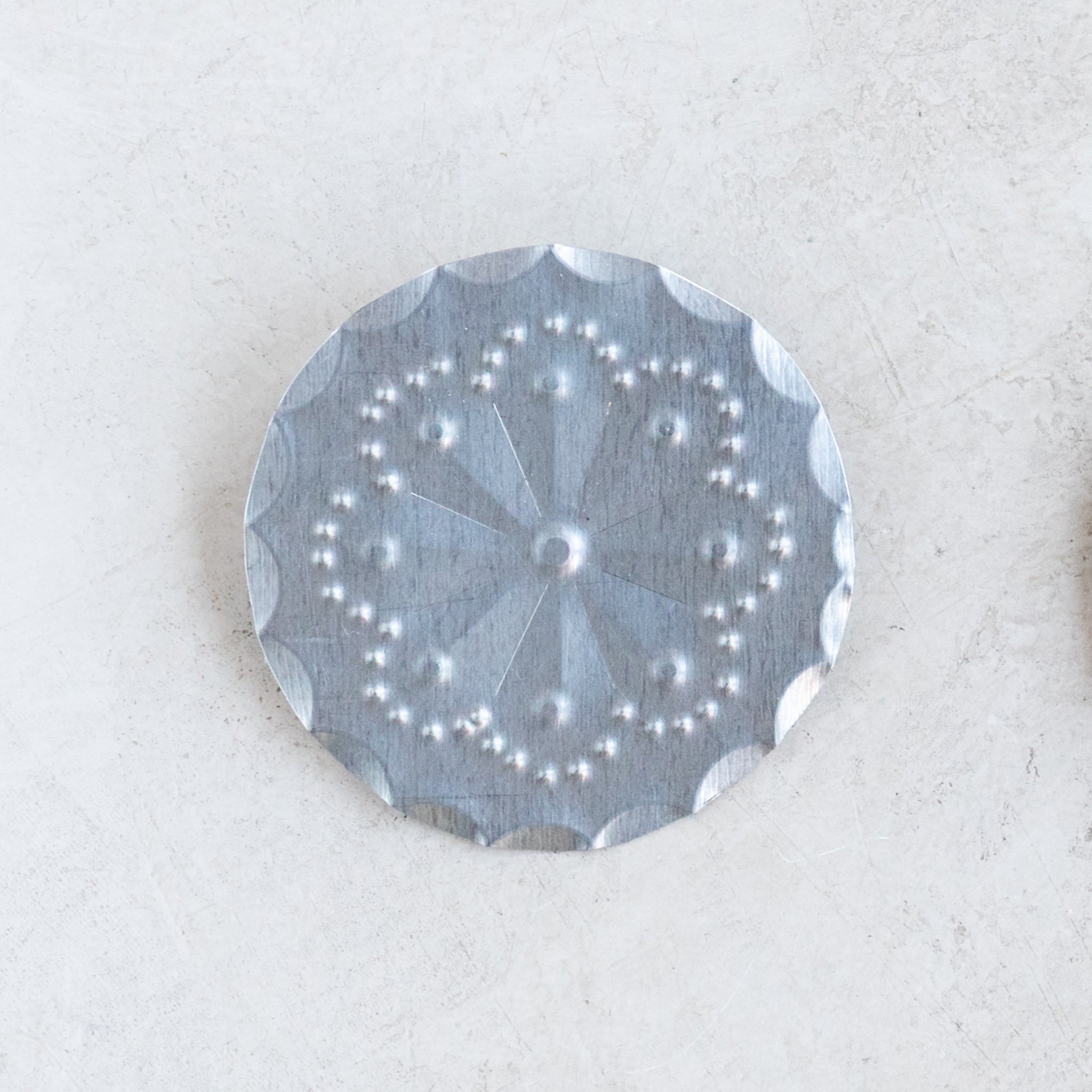 Front view of the Accent Roseta Pin with 2-inch hand-stamped rosette design in tin.