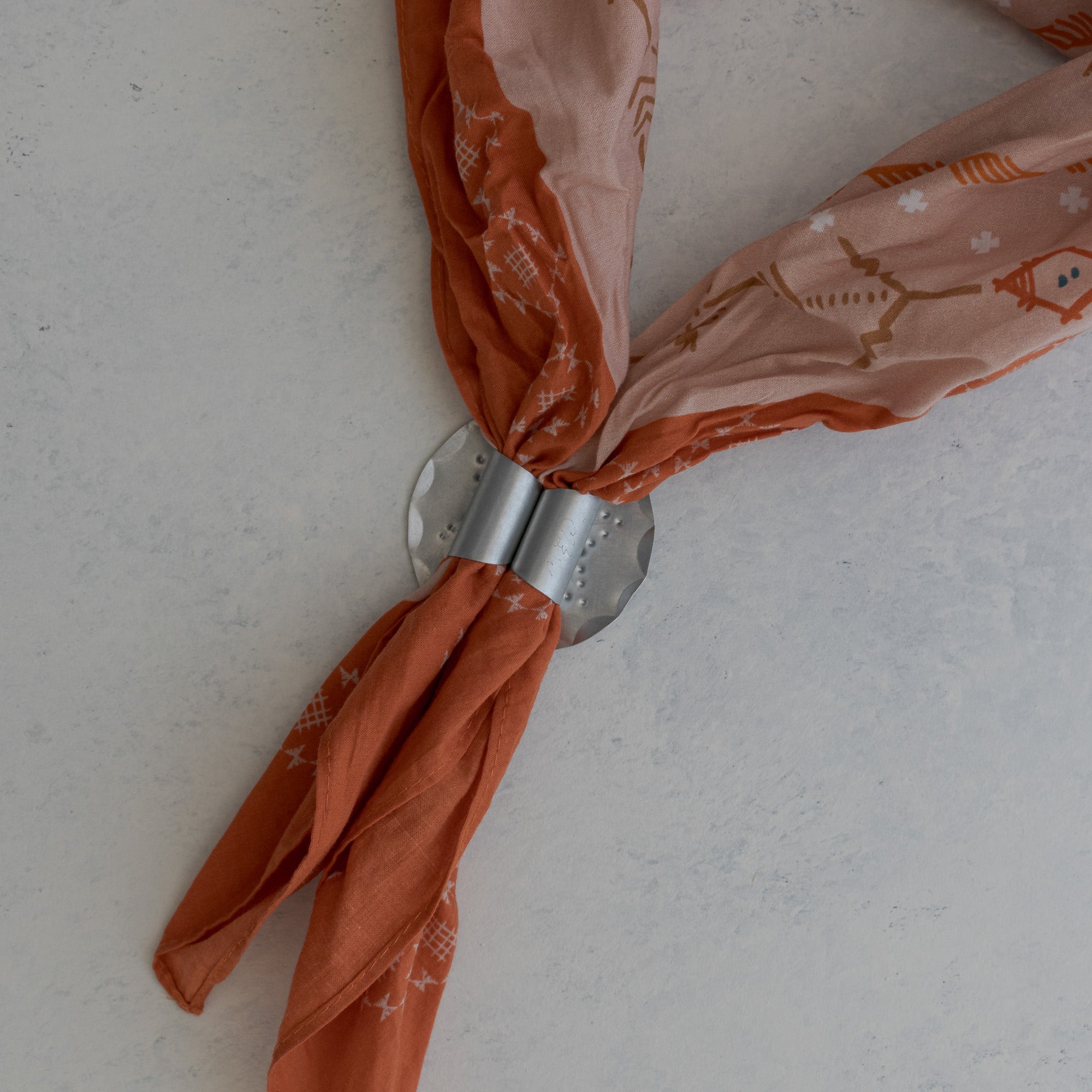 Tin Roseta bandana slide worn on a printed bandana, handmade in Santa Fe