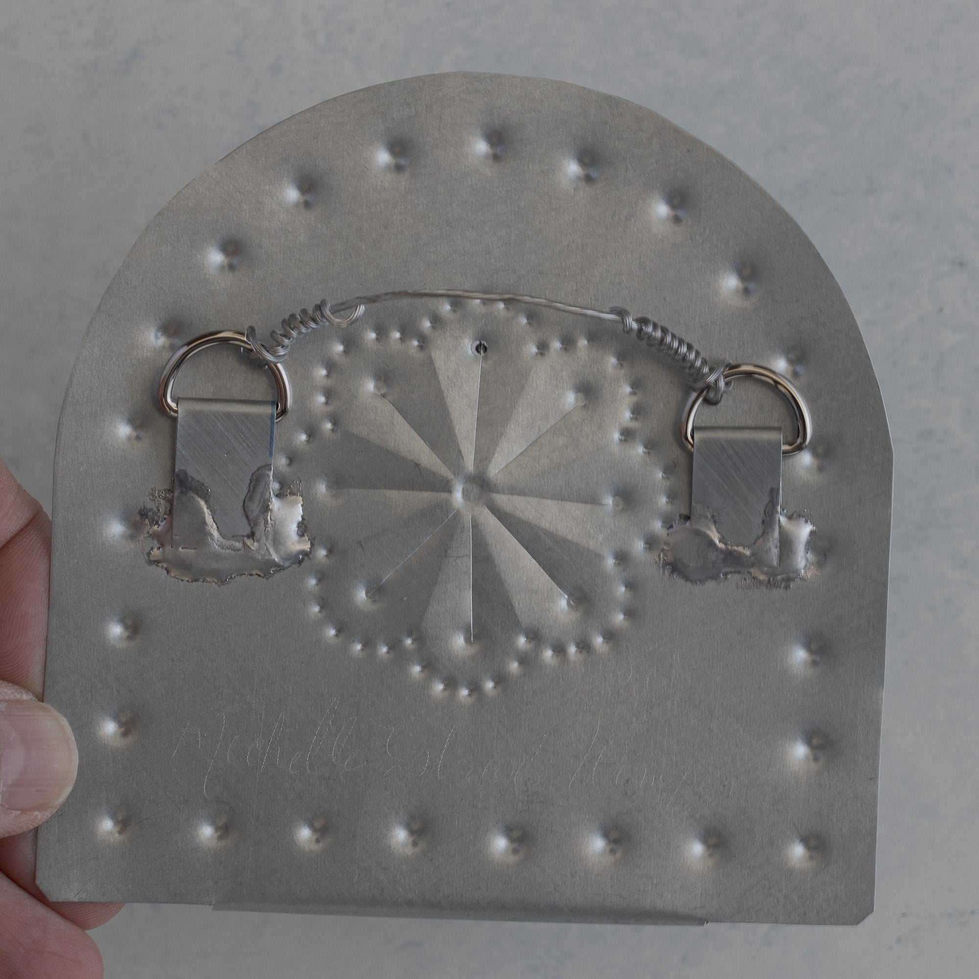 Back of a Homekeep tin tealight candleholder showing two D-rings with vinyl coated hanging wire, handmade in Santa Fe