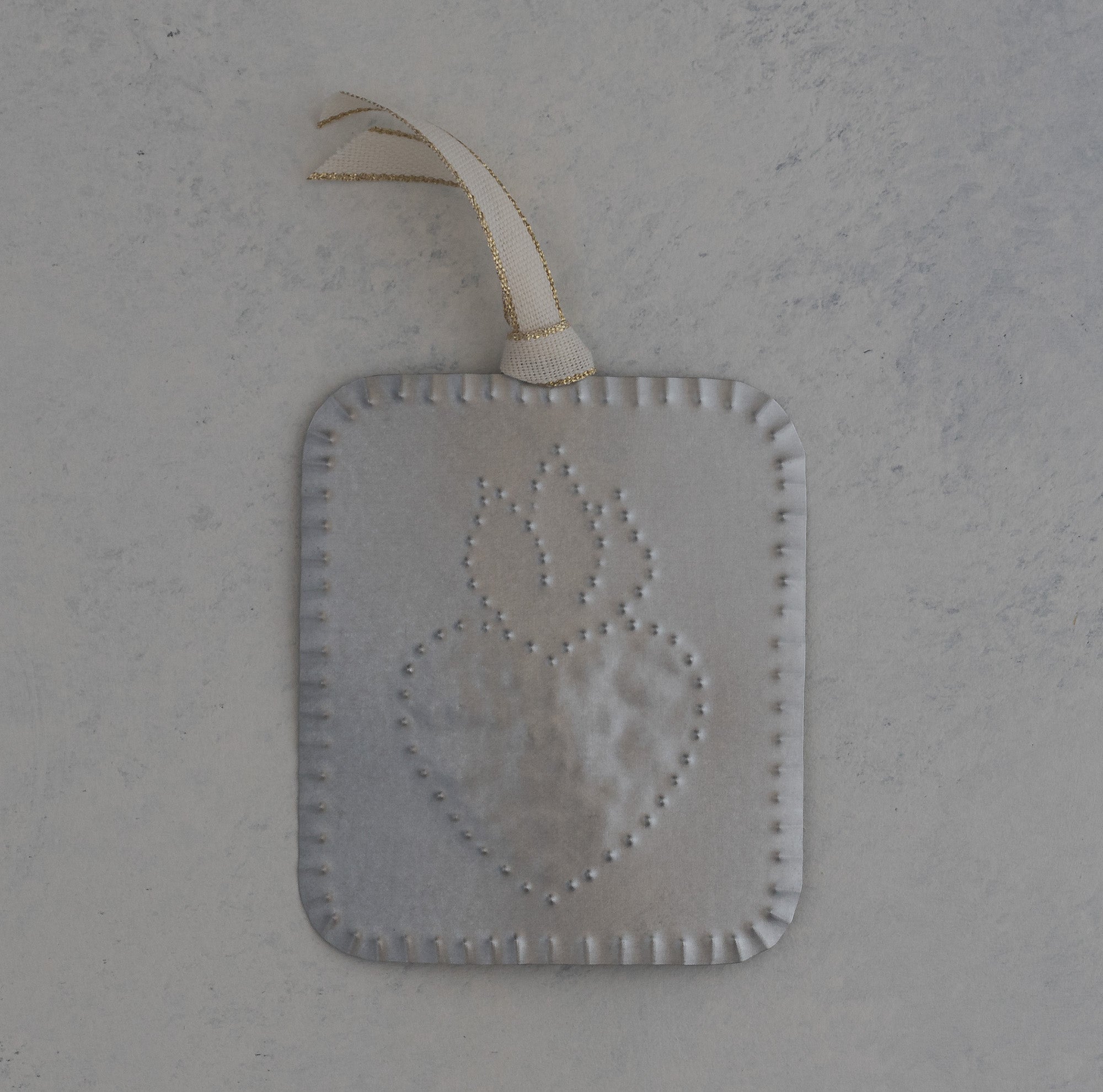 Hand punched tin sacred heart milagro ornament with scalloped edge and gold trimmed ivory ribbon, handmade in Santa Fe