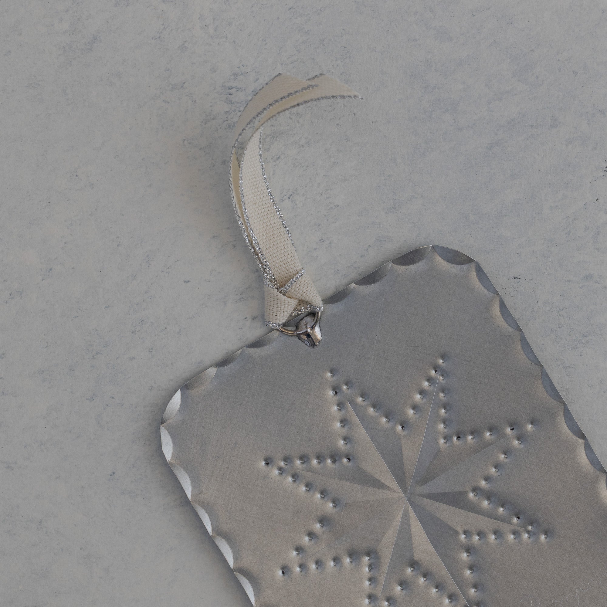 Back of the Star Milagro showing scalloped edge and silver threaded ivory ribbon