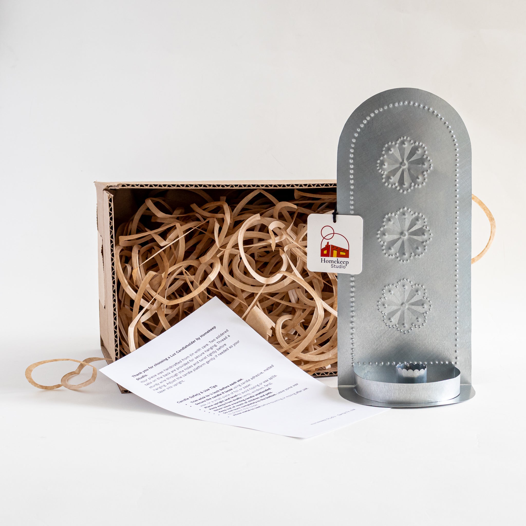 Roseta Trio Taper Holder tin candleholder packaged in kraft box with paper fill and care card.
