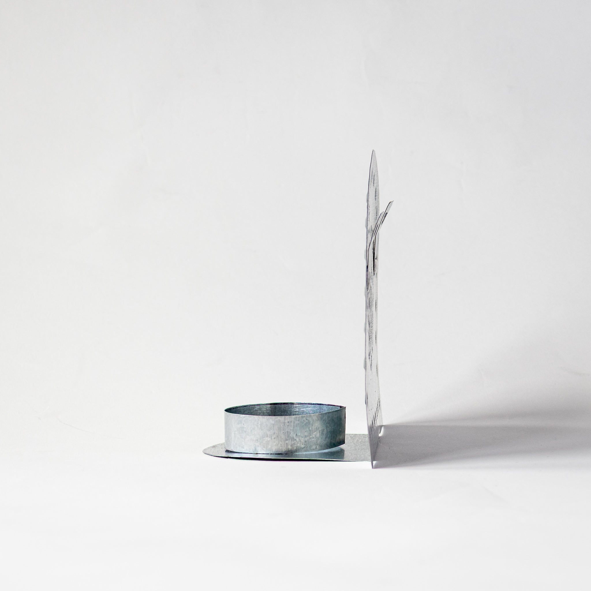 Side view of Luz Roseta Tealight Holder in hand-punched tin, showing depth of candle cup.