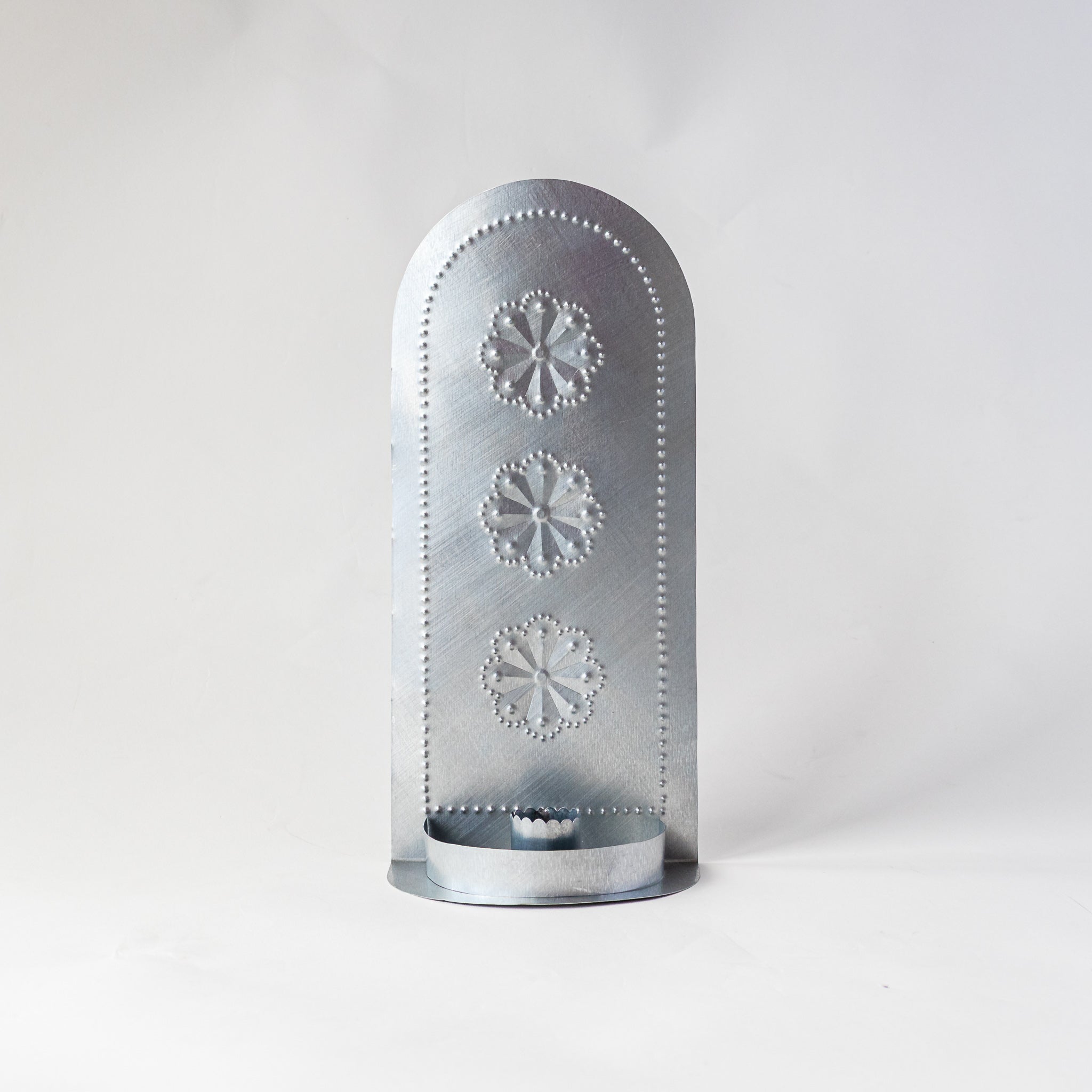 Front view of the Roseta Trio Taper Holder featuring three hand-punched rosette patterns.