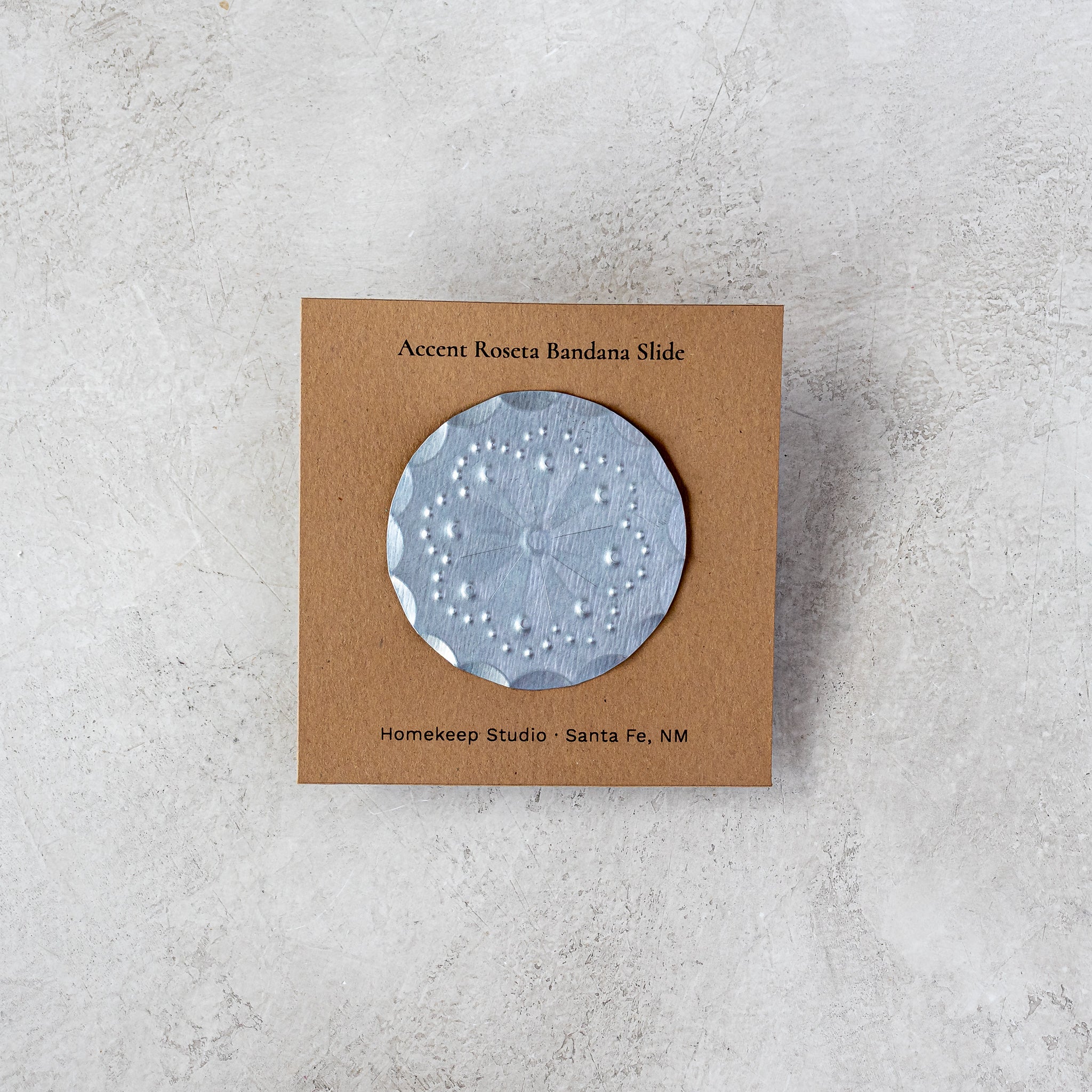 Roseta bandana slide attached to kraft card backing with Homekeep Studio branding, photographed on a neutral surface