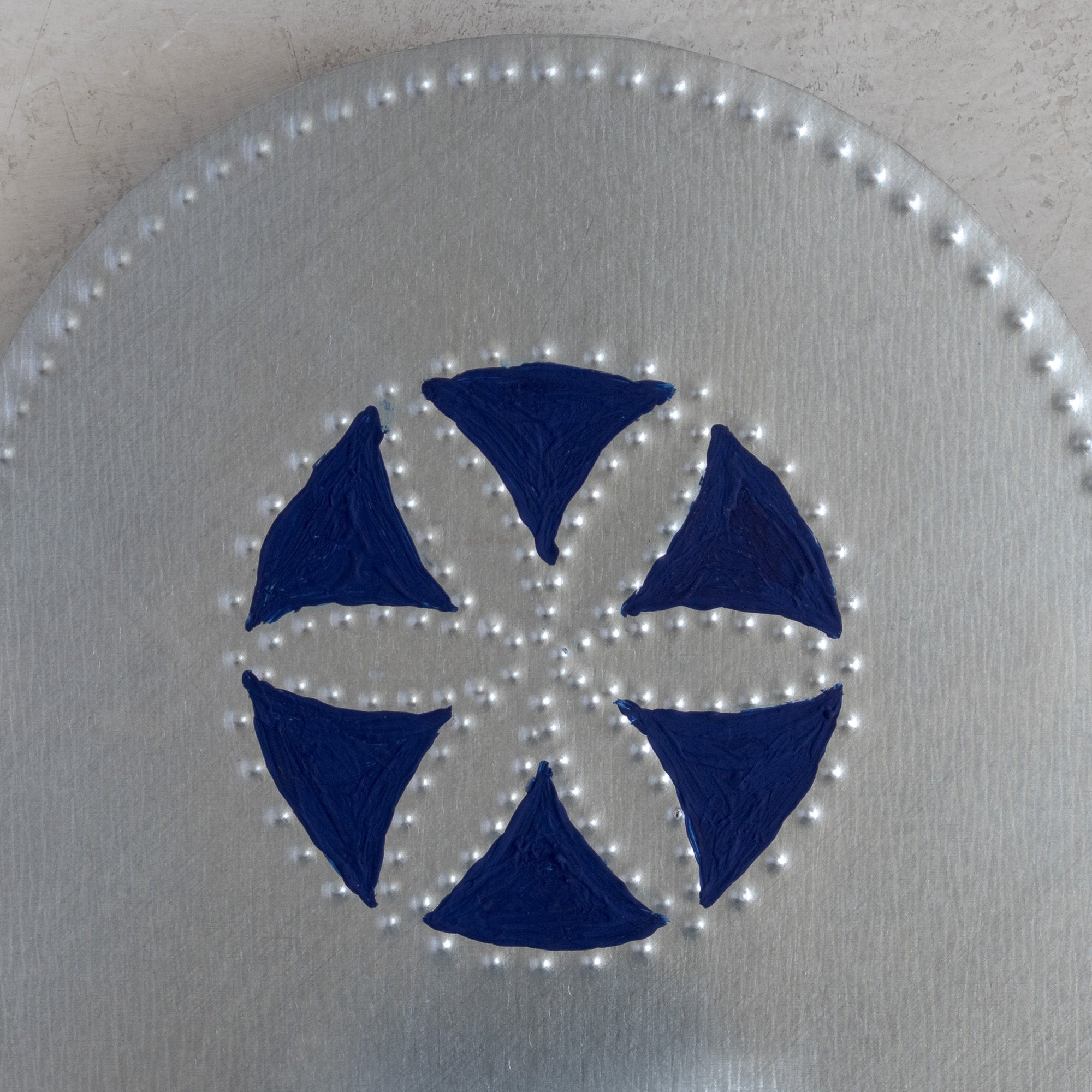 Detail of hand-painted blue flor pattern on tin tealight candleholder