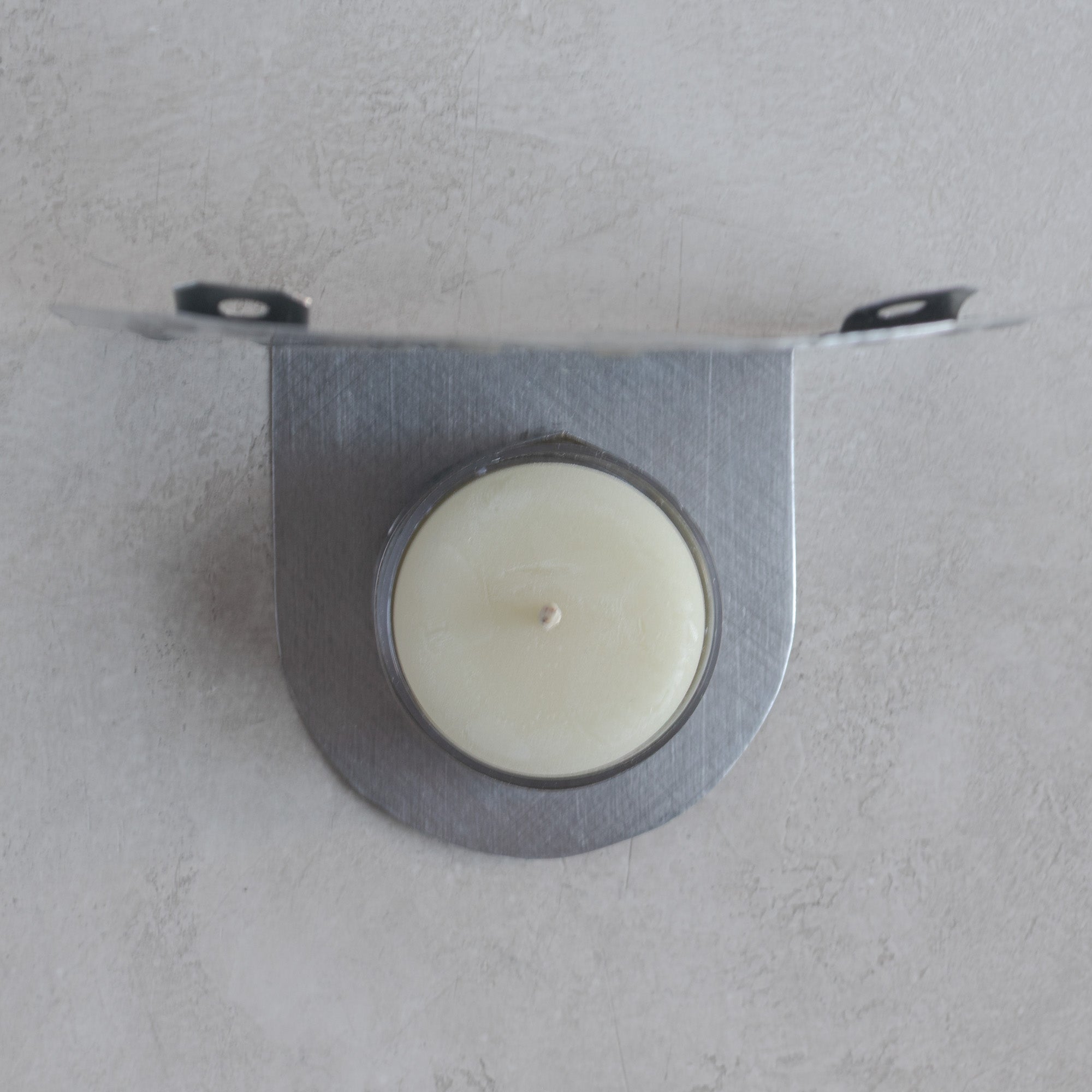 Top view of handmade Luz Roseta tin tealight candleholder showing candle cup and hanging tabs