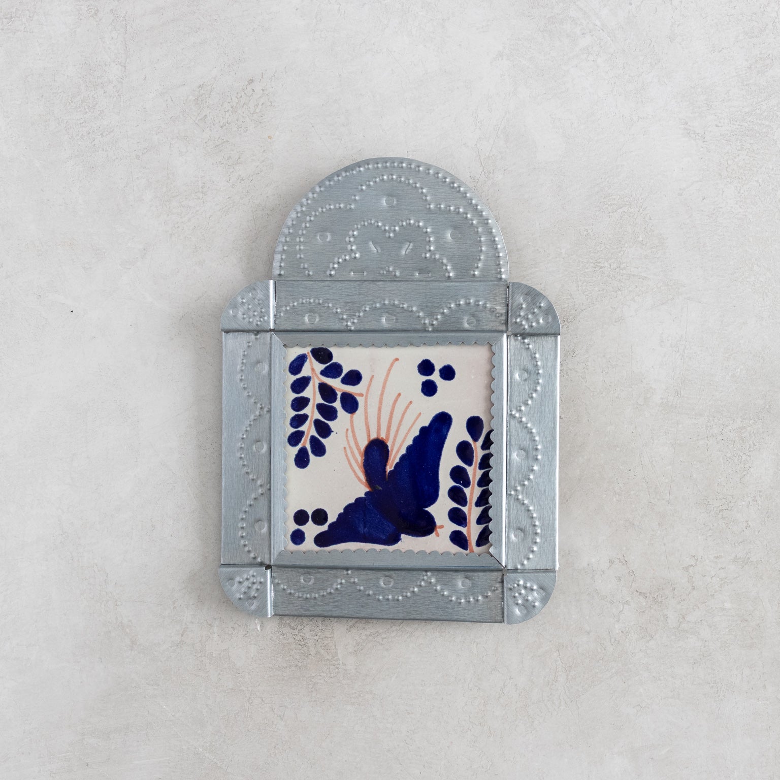 Decorative tinwork framed tile wall art with a bird design on a light gray background