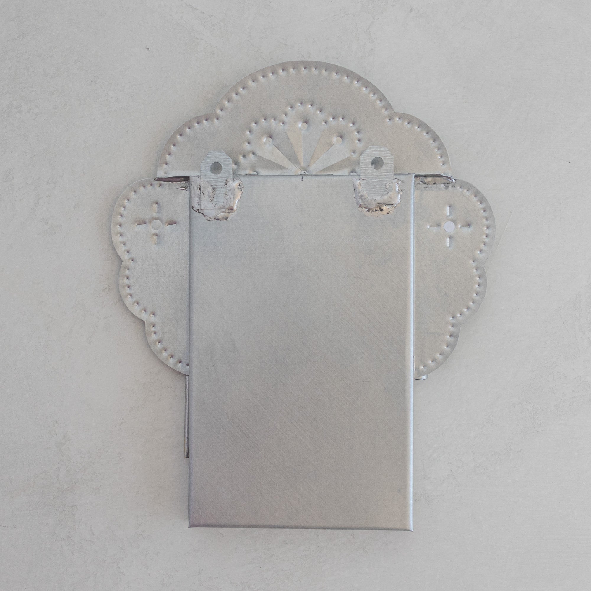 Back of Nicho Postal showing cloud crest form, two hanging tabs, and tin box construction in natural tin.