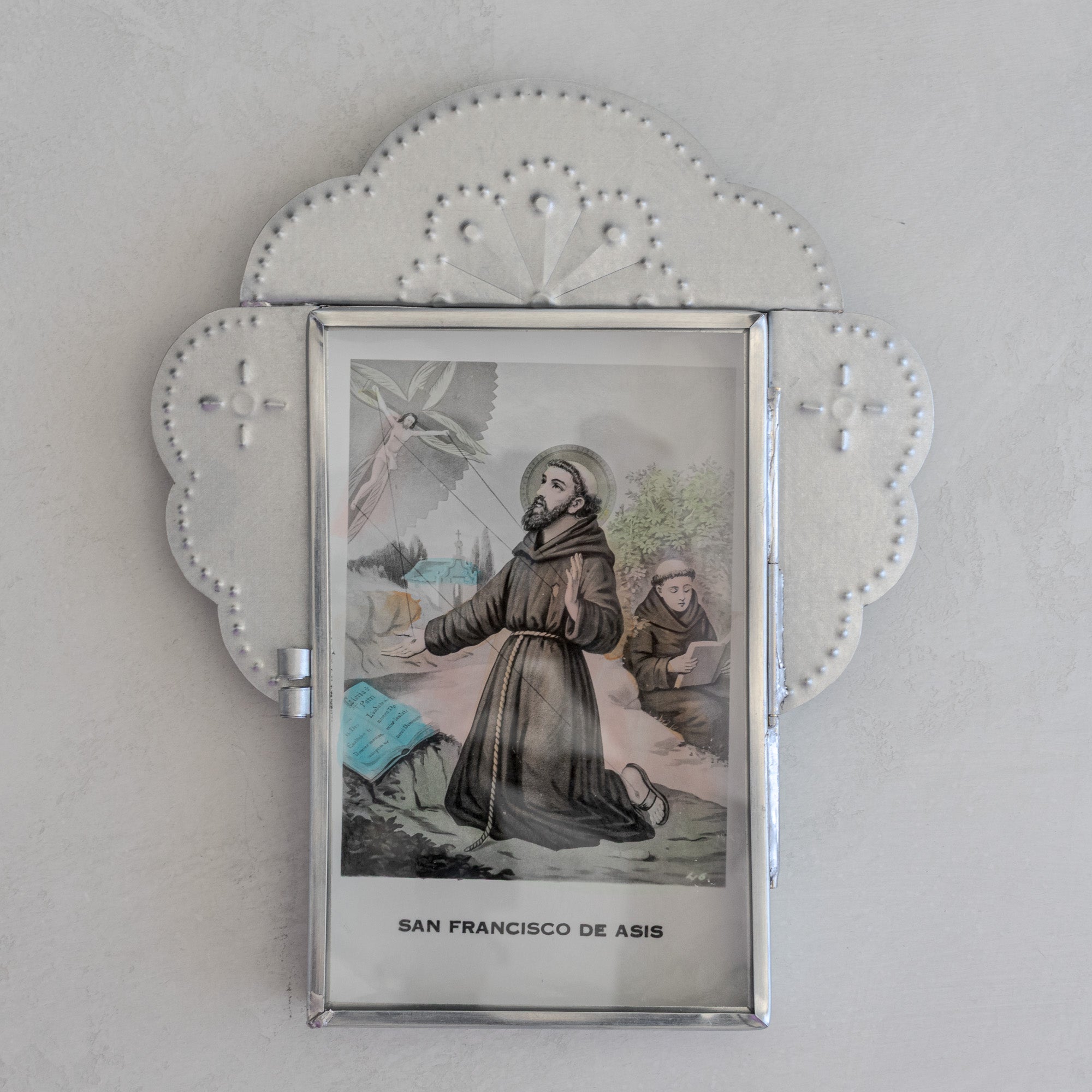 Nicho Postal with glass door closed holding a vintage Mexican postcard of San Francisco de Asis, natural tin cloud crest form with fan motif above.