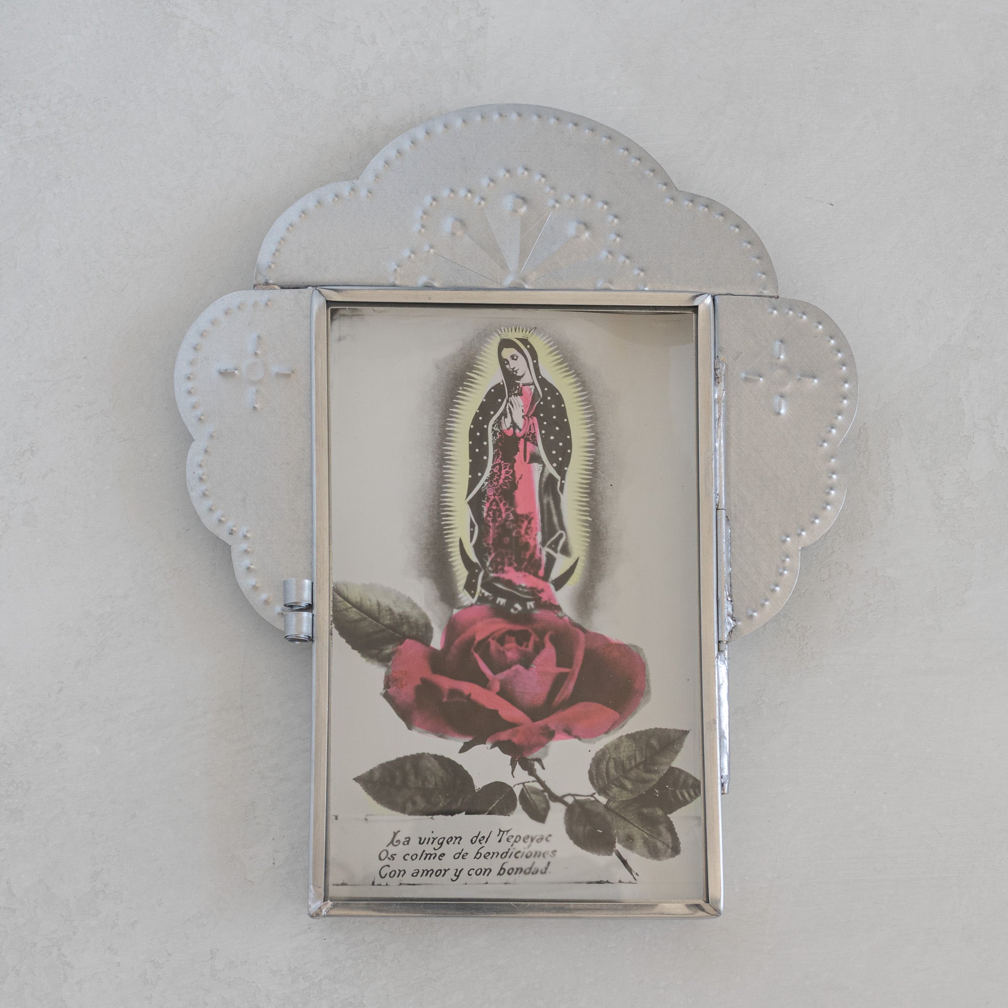 Nicho Postal with glass door closed holding a vintage Mexican postcard of La Virgen del Tepeyac with a red rose, natural tin cloud crest form with fan motif above.