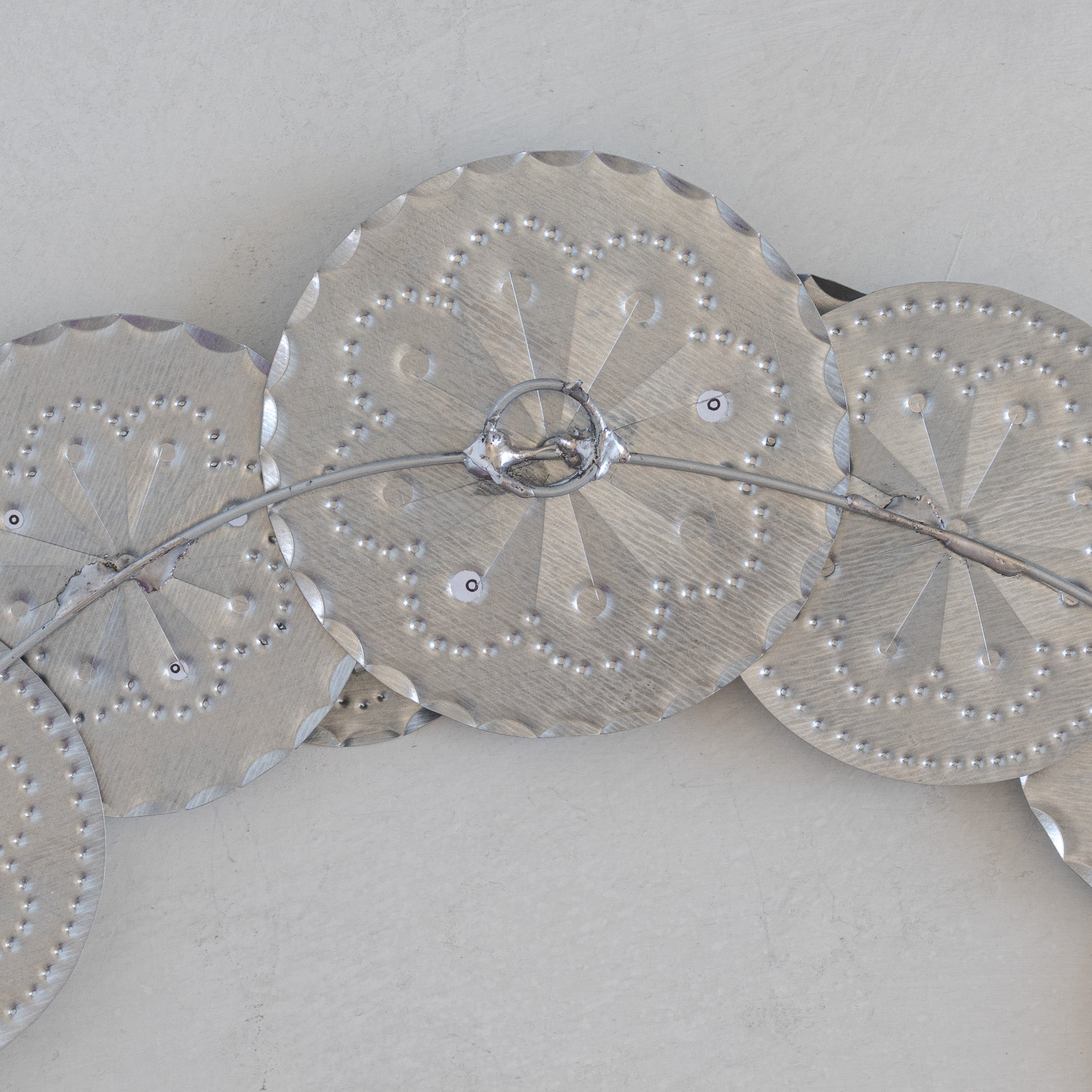 Back view of Roseta Corona tinwork wreath showing wire armature and hanging loop construction.